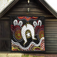 Black Aboriginal pattern quilt hung indoors, showing white emblem with gold-outlined star