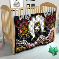 Black Aboriginal pattern quilt on a child bed, featuring white emblem with gold star