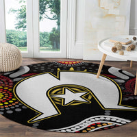 Round Aboriginal pattern rug showing black-and-white lightning bolt with yellow star and multicolor dots.