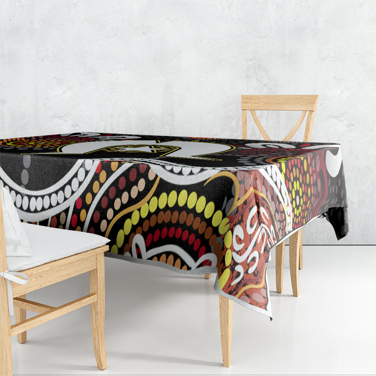 Multicolor aboriginal pattern tablecloth draped over rectangular table with black base