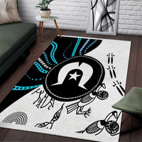 Multicolor Aboriginal-inspired area rug with central black-and-white emblem and dot accents.