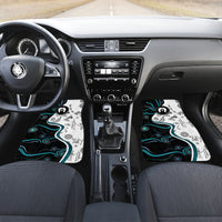 Car interior with two front floor mats featuring black, white, and blue Aboriginal-style art