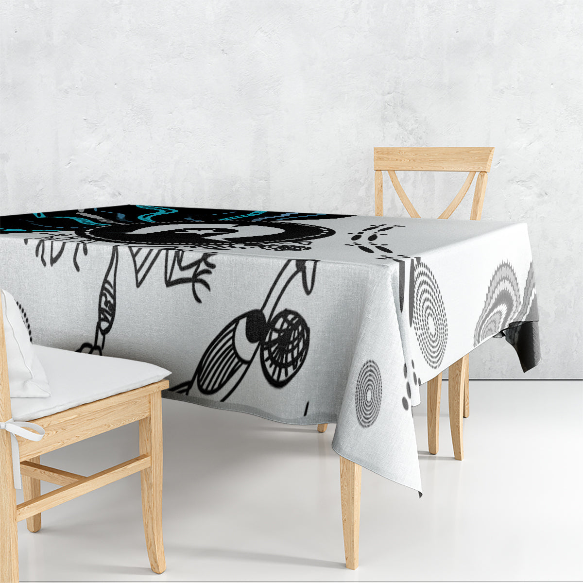 Aboriginal pattern tablecloth draped over table, black linework and circular teal accents