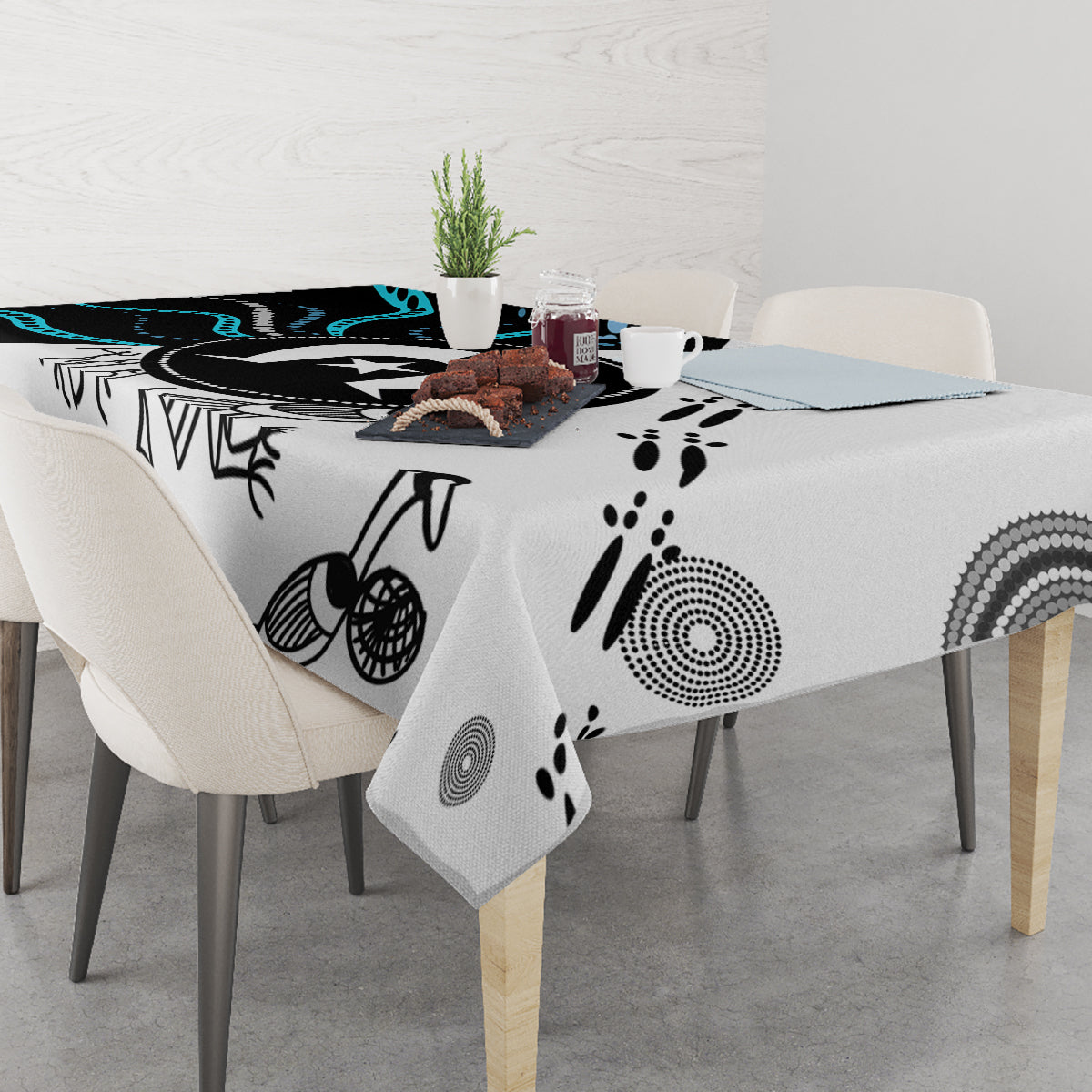 Aboriginal pattern tablecloth on dining table with black, white, and teal abstract motifs