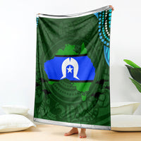 Green throw blanket with central flag graphic, teal dotted edge, draped upright