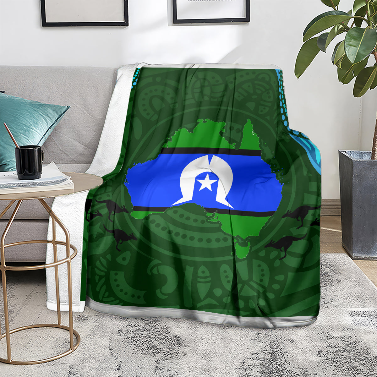 Green throw blanket with central flag graphic and Aboriginal pattern, draped on couch