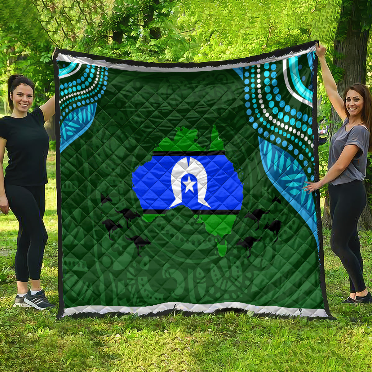 Green quilt with blue island emblem, teal dotted swirls, and black-and-white edge binding