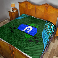 Green quilt with Aboriginal-style island pattern, blue emblem center, teal dot borders