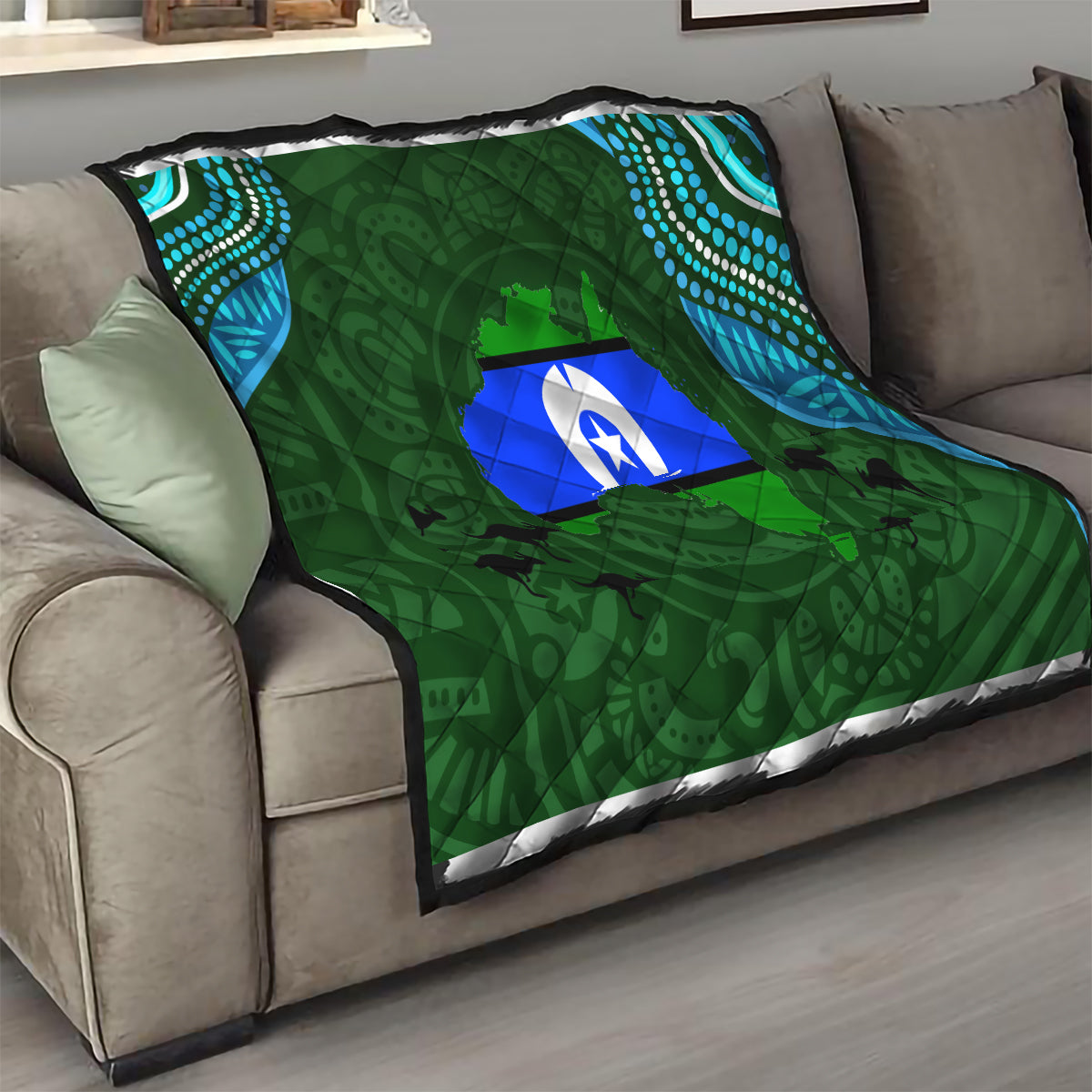 Green couch throw quilt with blue island emblem, teal dotted corner panels, black trim