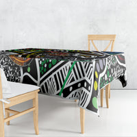 Abstract multicolor tablecloth with black base, white motifs, green dots, and orange border accents