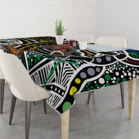 Multicolor patterned tablecloth with black, green, yellow, white, and orange dot and line motifs