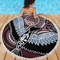 Round beach blanket with fringe edge, multicolor Aboriginal bird design, laid on wooden deck.