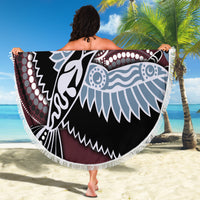 Round beach blanket with fringe edge, multicolor bird motif in Aboriginal style, held on beach.