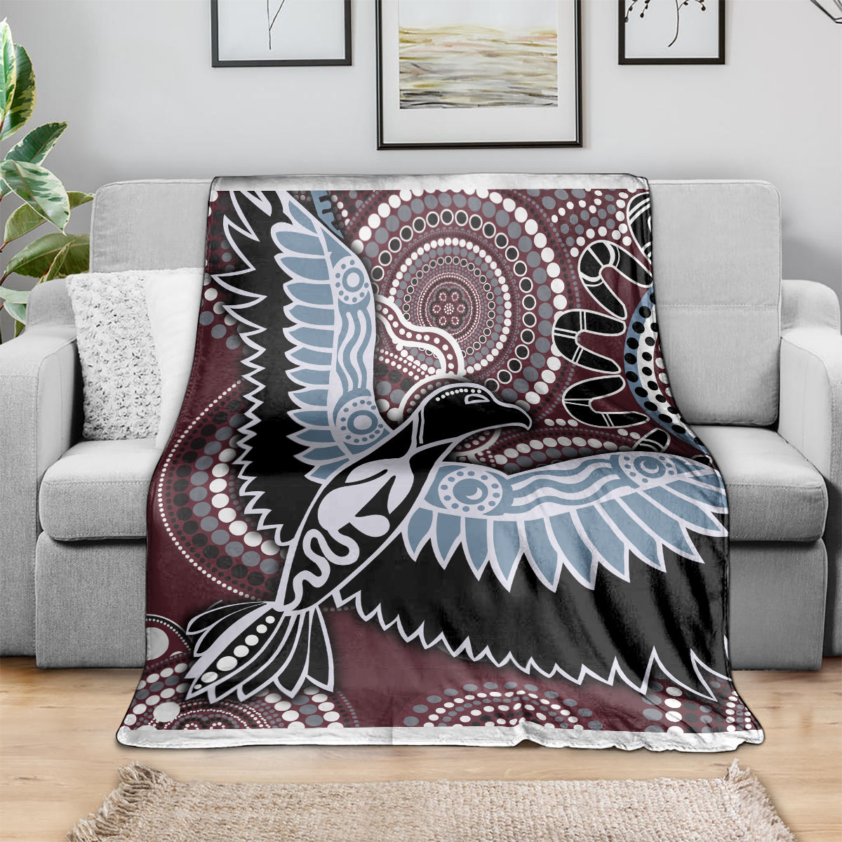 Bird pattern blanket draped on sofa: maroon, black, light blue, and white geometric details