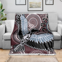 Bird pattern blanket draped on sofa: maroon, black, light blue, and white geometric details