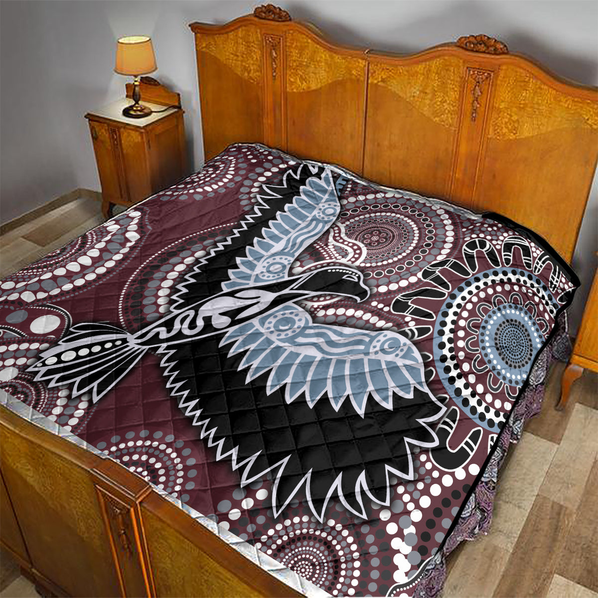 Burgundy bird motif quilt with light-blue wings, black accents and quilted diamond stitching
