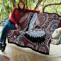 Burgundy quilt showing a large Aboriginal bird design in light blue, black and white patterns