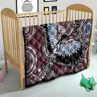 Burgundy bird motif quilt on a small bed, with light-blue wing details and dotwork circles