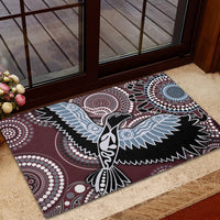 Aboriginal-pattern rubber doormat with central bird design and circular motifs in maroon and blue