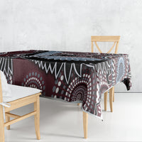 Rectangular bird-pattern tablecloth draped on a dining table in maroon and blue motifs.