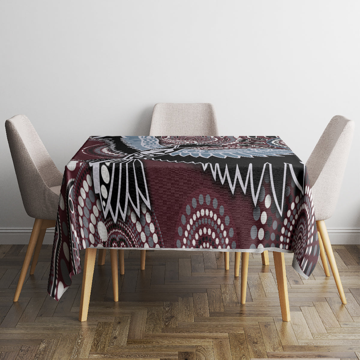 Bird-pattern tablecloth covering a table center, maroon and black with blue and white details.