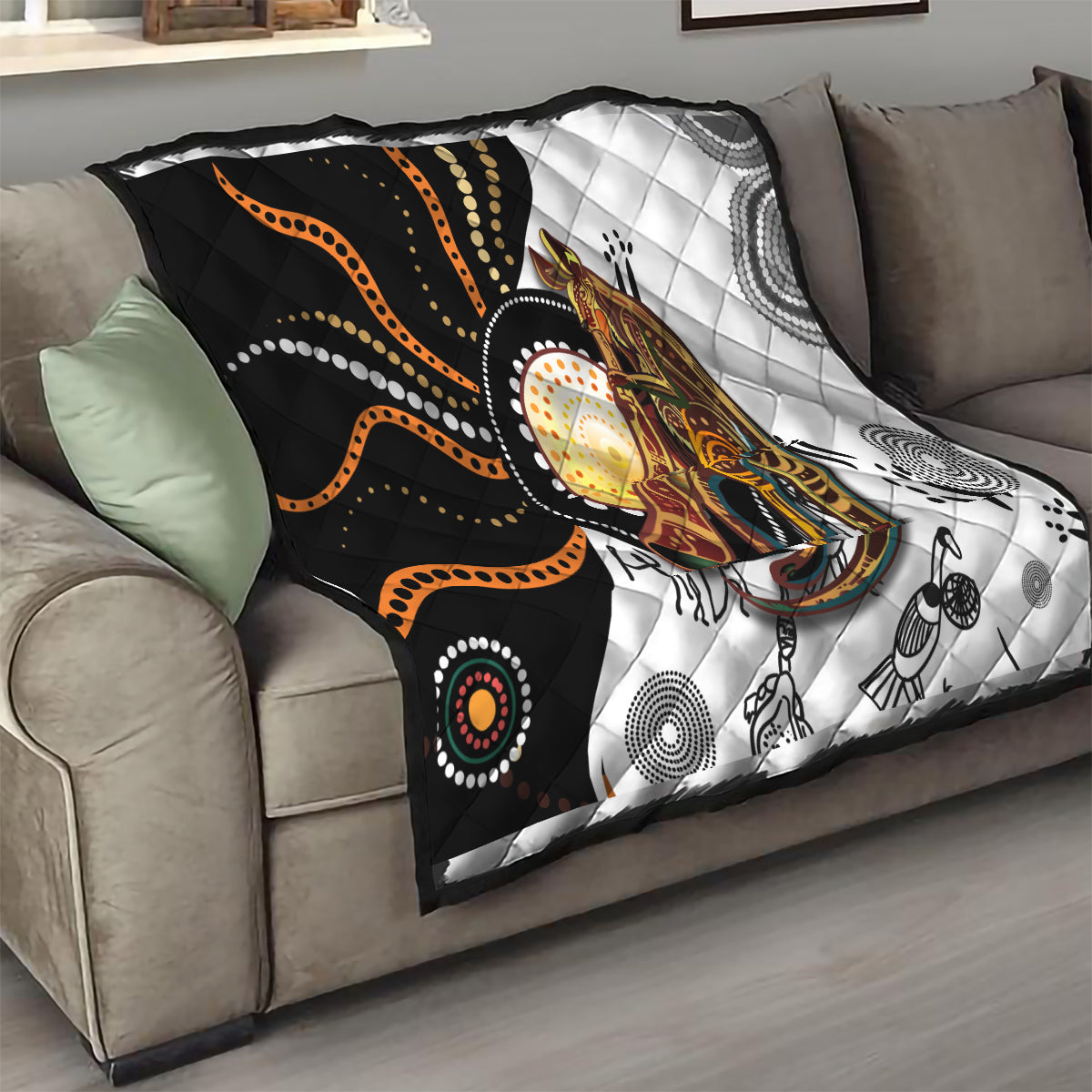 Quilt draped over sofa arm showing black, white, and orange dotted kangaroo artwork