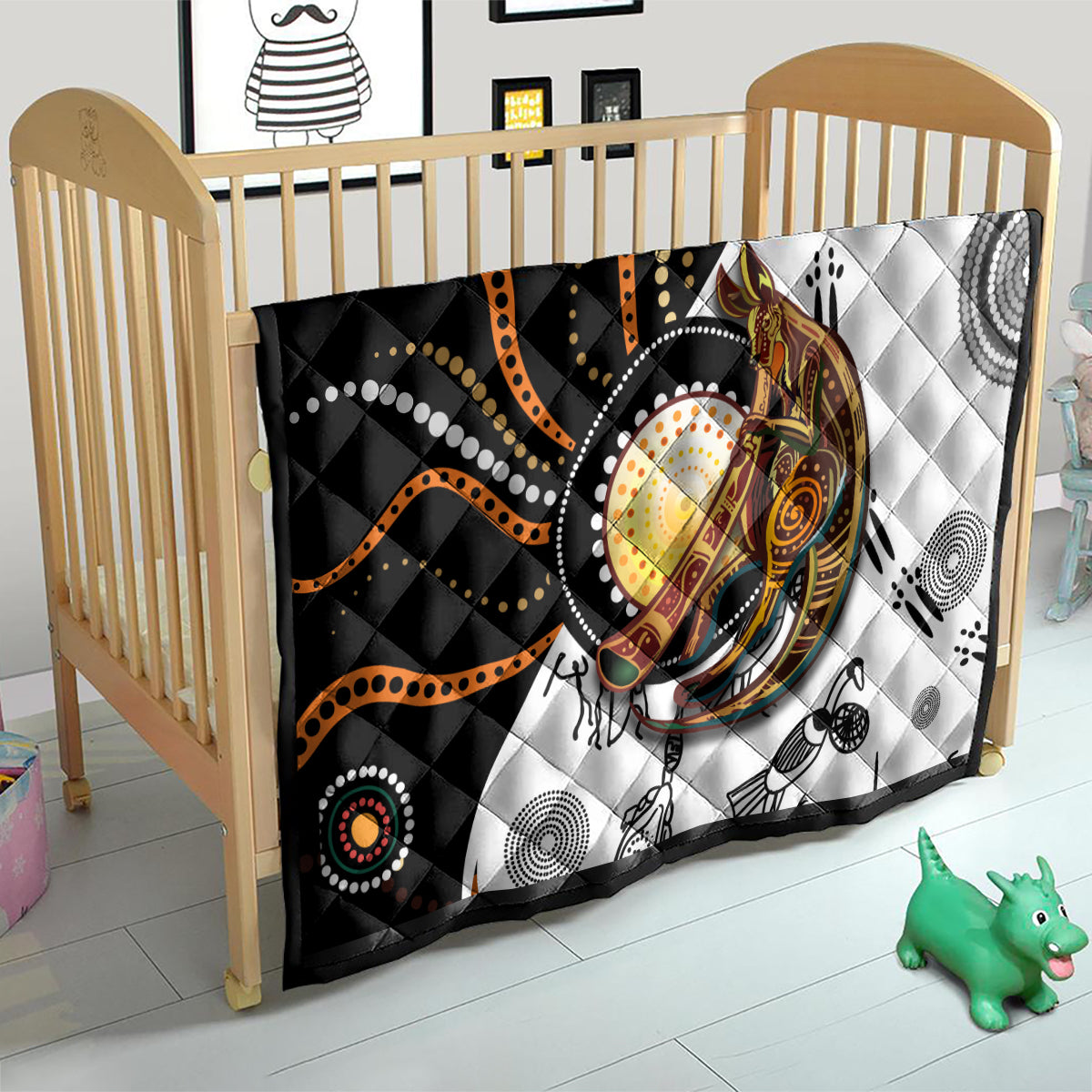 Quilt on a toddler bed with black, white, and orange dotted kangaroo pattern