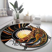 Round rug with Aboriginal-inspired kangaroo and dot patterns in black, orange, and green trim