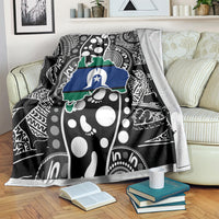 Aboriginal pattern blanket draped over sofa, black base with white dots and blue-green map
