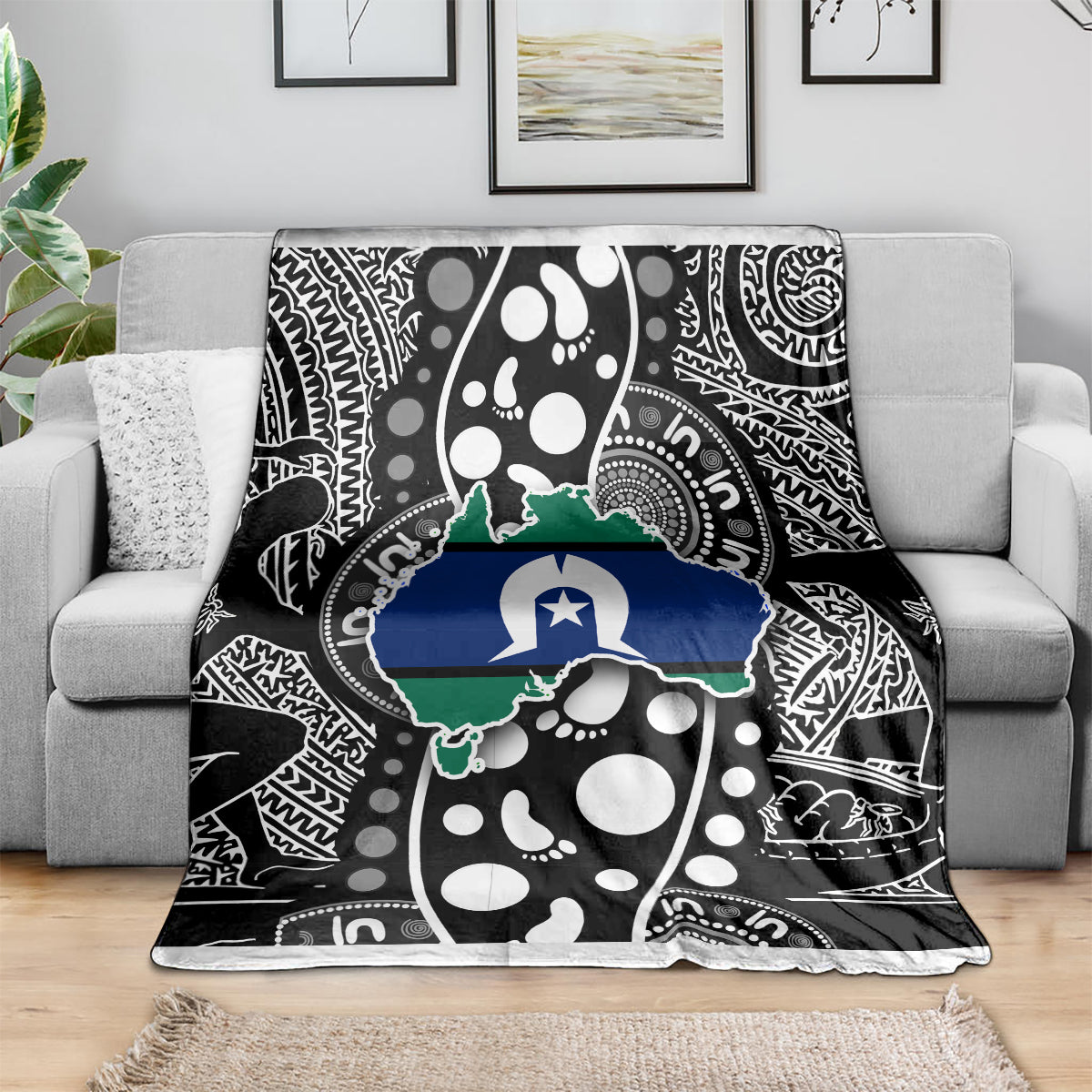 Aboriginal pattern throw blanket on gray sofa, black and white with blue-green Australia outline