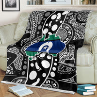 Close view of Aboriginal pattern blanket on couch, black, white, green, and blue map artwork