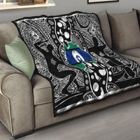 Aboriginal pattern quilt draped on sofa, black-and-white motifs with blue star and green map center
