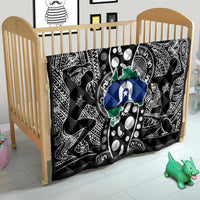 Aboriginal pattern quilt on a child bed, black-and-white tribal print with blue star and green map
