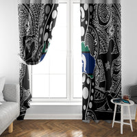 Black and white patterned curtain panel with multicolor map section by a window