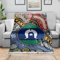 Multicolor aboriginal pattern blanket with circular flag-style emblem on gray couch