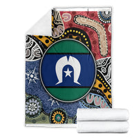 Multicolor aboriginal pattern blanket with circular flag-style emblem, folded with white towels