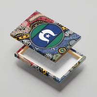 Multicolor Aboriginal patterned canvas wall art with circular emblem, angled view.