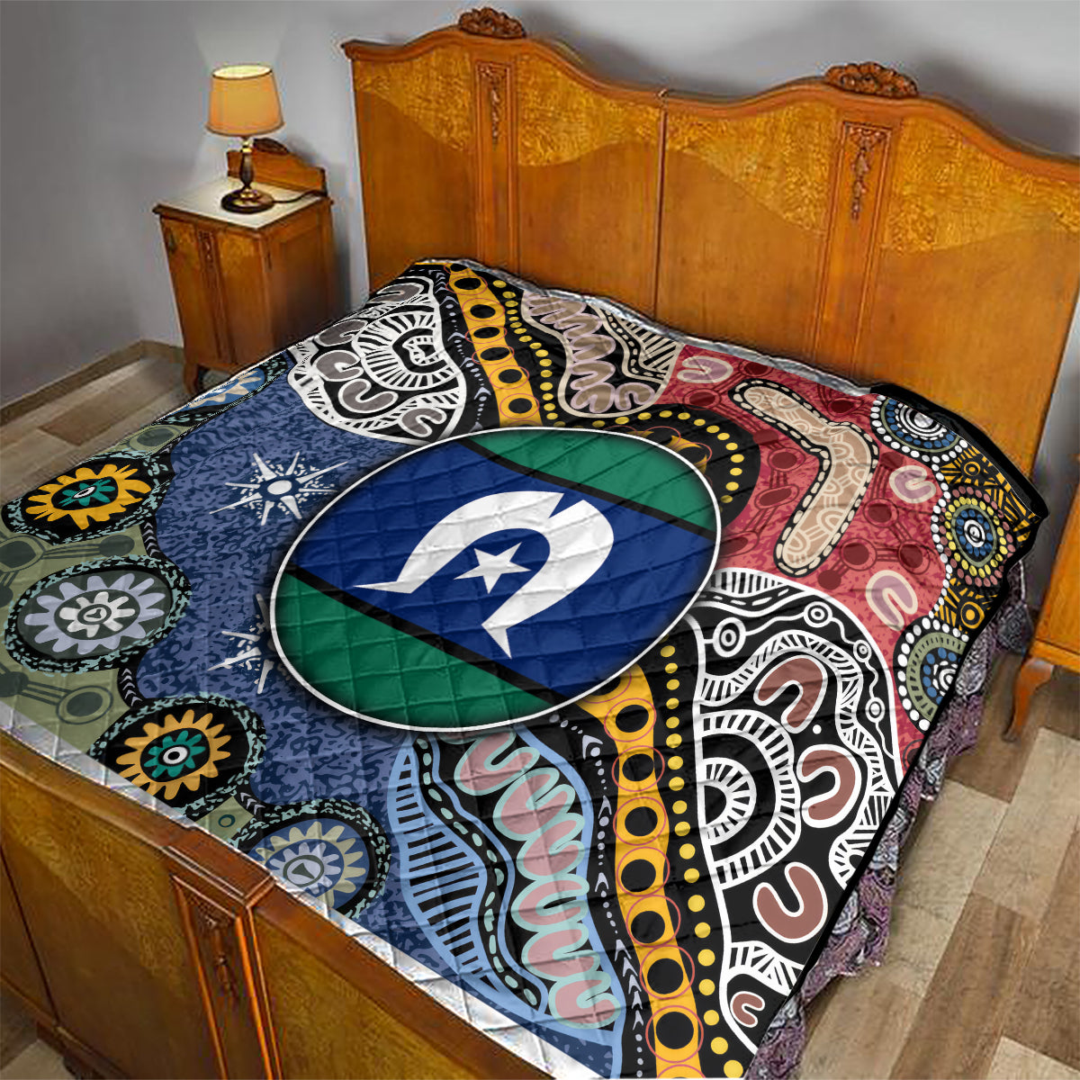 Multicolor Aboriginal pattern quilt draped on bed, oval star emblem in blue and green