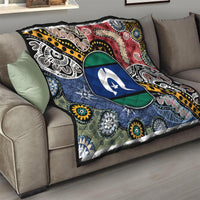 Aboriginal pattern quilt on sofa, oval star emblem with multicolor tribal motifs and trim