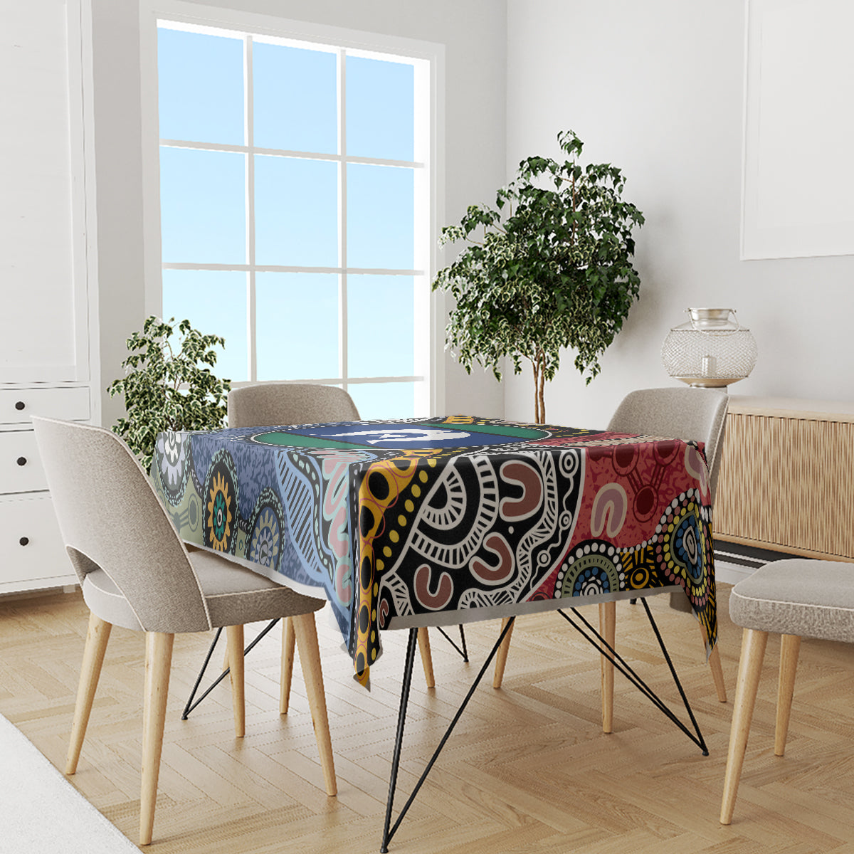 Rectangular tablecloth with bold multicolor Aboriginal pattern, draped over dining table