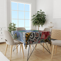 Rectangular tablecloth with bold multicolor Aboriginal pattern, draped over dining table