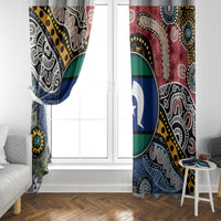 Multicolor Aboriginal curtain panels framing a window with circular emblem