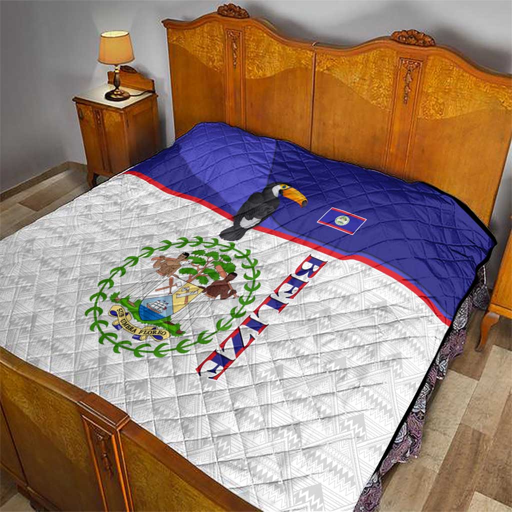 Blue and white bed quilt with toucan and Belize emblem, quilted diamond texture