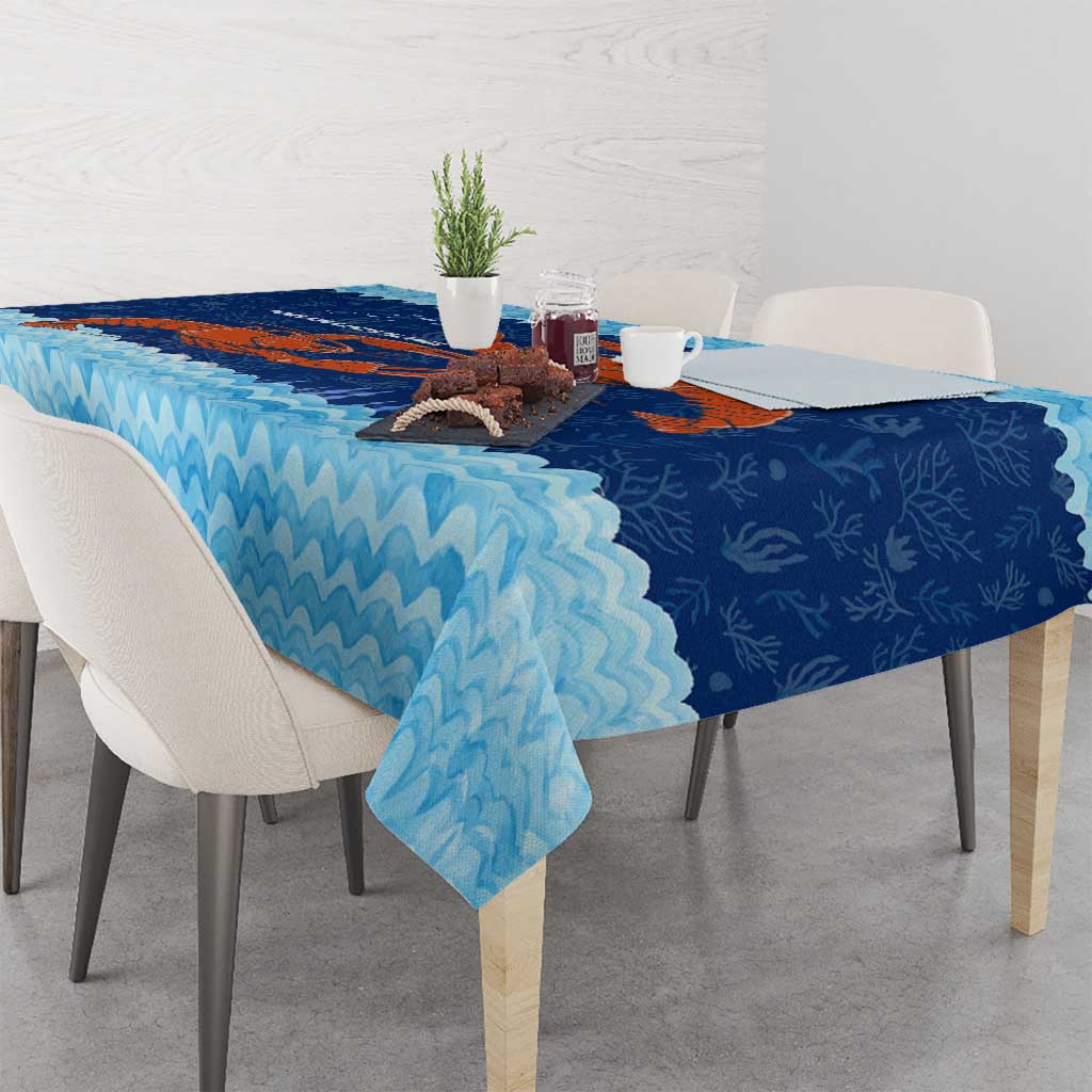 Blue tablecloth with ocean-wave border and red crab coral reef artwork, side view