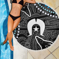 Round fringed beach blanket showing black-and-white tribal pattern with blue dot highlights