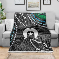 Aboriginal pattern blanket draped on sofa, black and white with blue beads and green accents