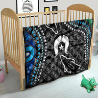 Multicolor quilt over a wooden crib, black-and-white animal figure with star and blue dot pattern