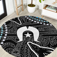 Round tribal-style carpet with black base, white/gray patterns, and small blue accents