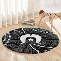 Round black patterned carpet with central emblem in white/gray and light blue accent spots