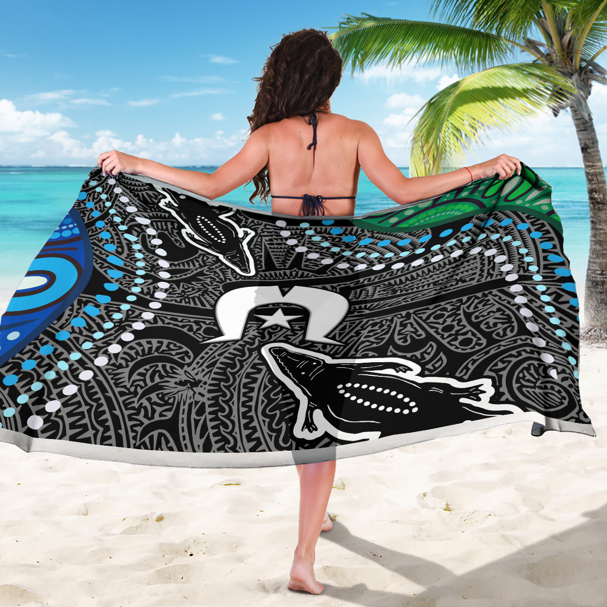 Black and white sarong with detailed tribal motifs, blue dot accents, and emblem center